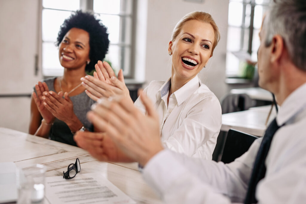 Happy colleagues applauding during a business meeting in the office